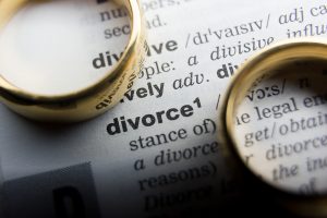 Picture of two wedding rings on top of a paper displaying the definition of divorce.