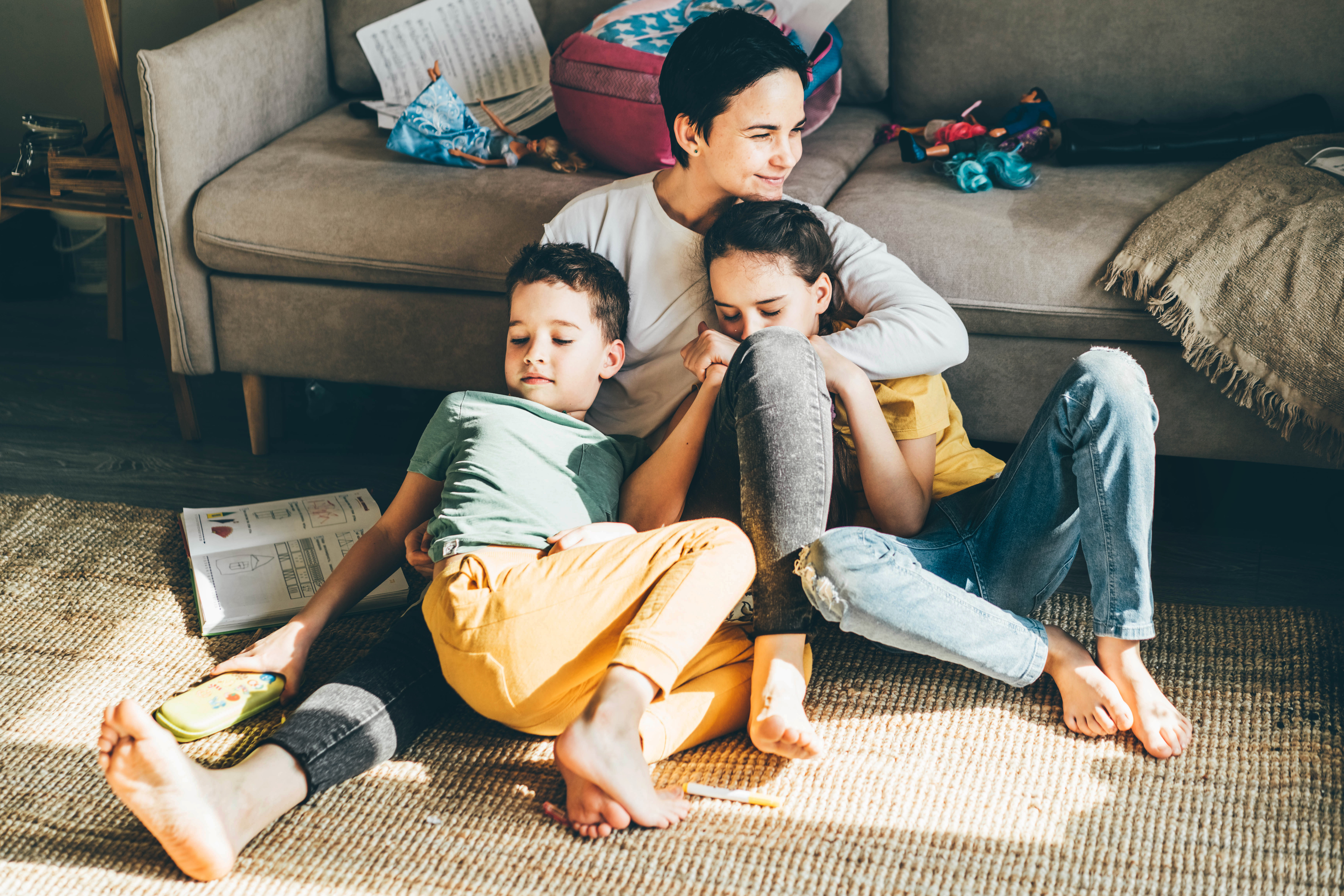 Happy mother sitting on the floor with her two kids.