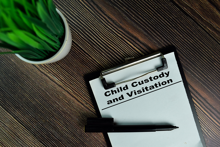 Child Custody and Visitation write on a paperwork isolated on Wooden Table.