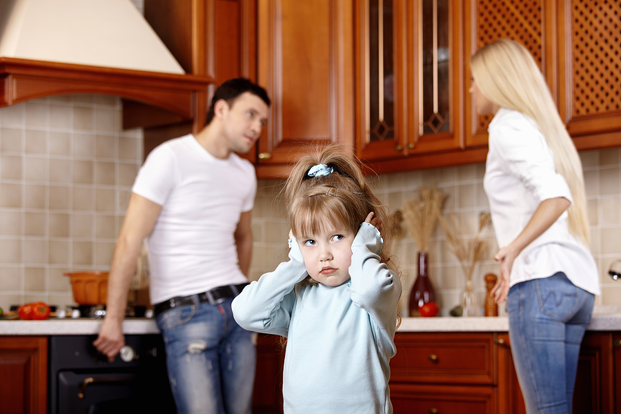 Young girl in the foreground of quarreling parents.