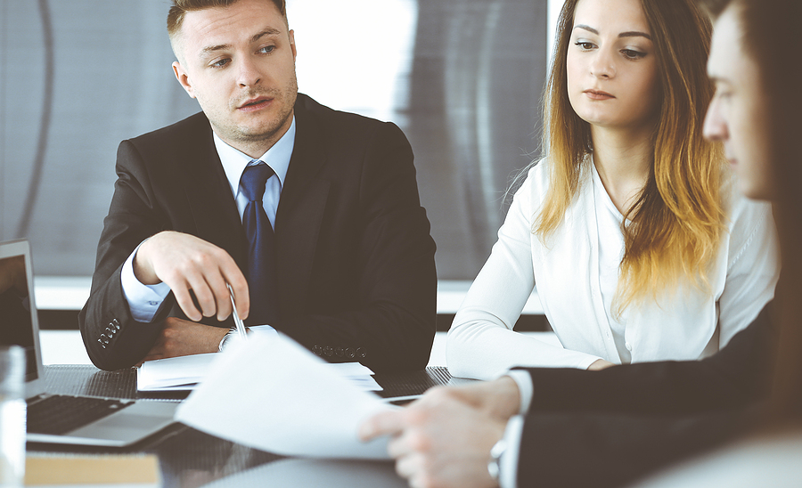 Business people or lawyers discussing questions at meeting in modern office. 