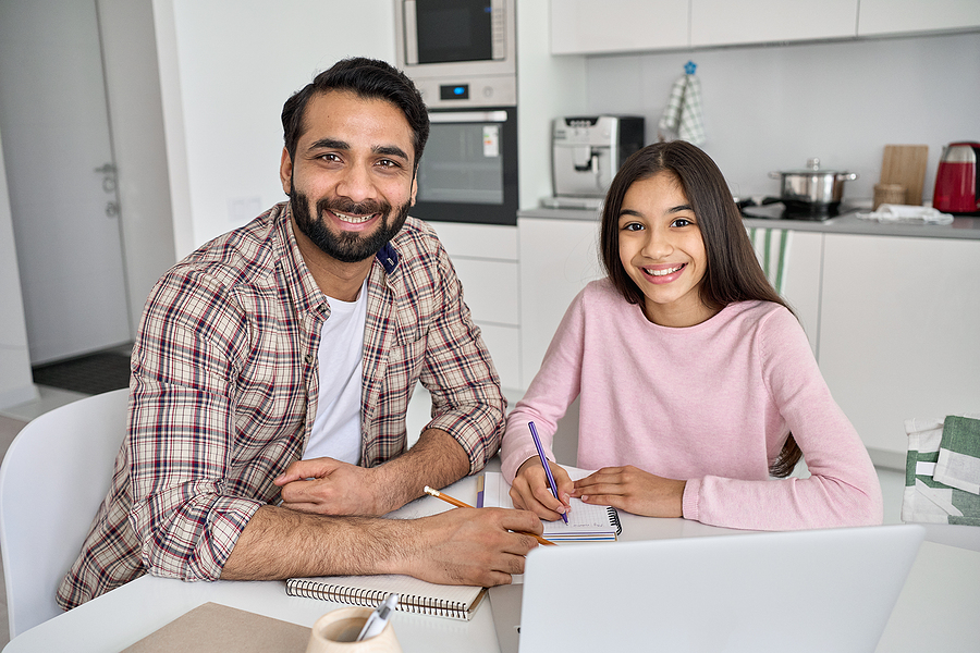 Father helping teen daughter with her homework.