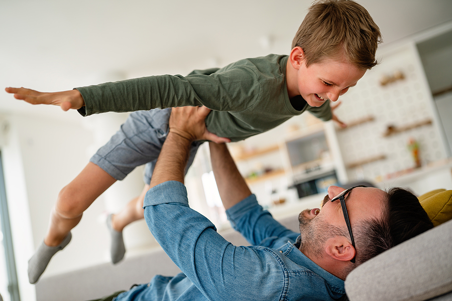 Joyful father and son having fun, spending time at home together. Single dad concept