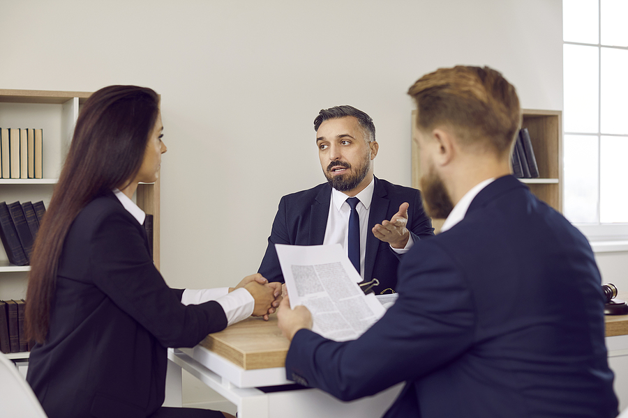 Family lawyer giving consultation to couple concerning divorce settlement agreement