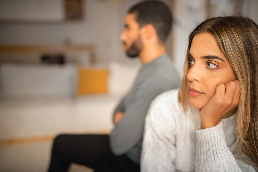 Sad offended international millennial couple think about divorce after quarrel in living room interior, close up