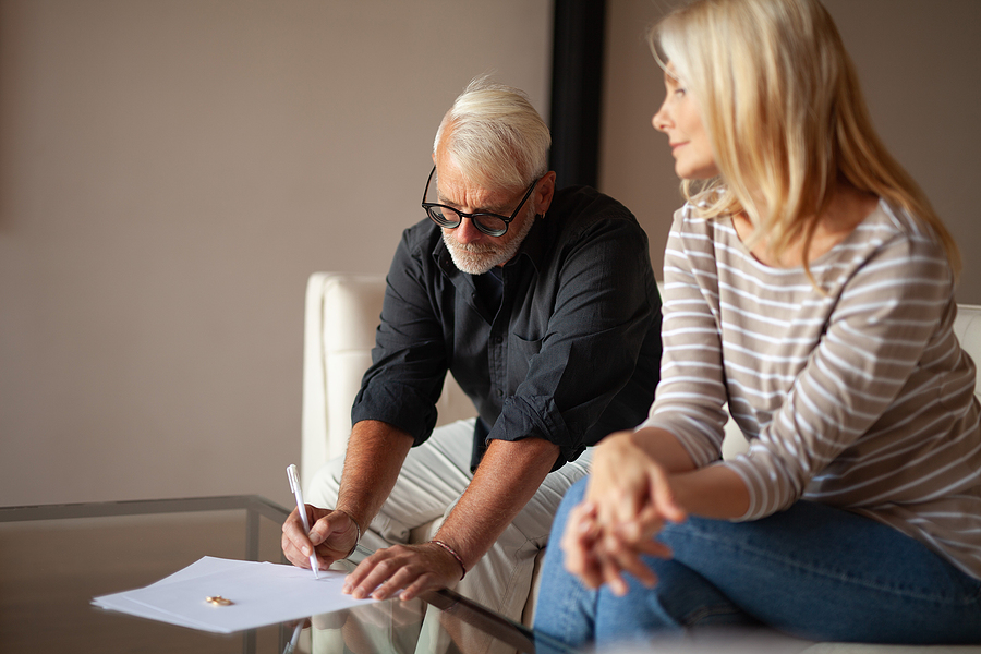 Sign divorce papers. Mature man and woman with documents on division of property. 