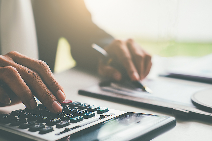 Woman with bills and calculator. Woman using calculator to calculate bills at the table in office. Calculation of costs.