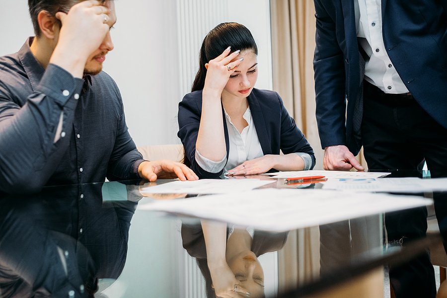 Man and woman who appear to be in the early stages of a divorce, meeting with a lawyer. 