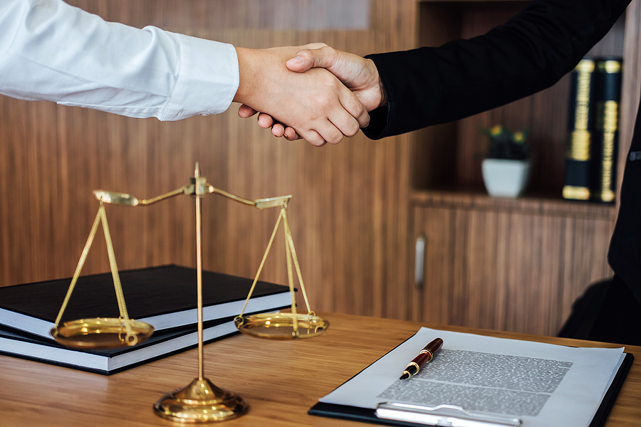 Close up of a handshake between attorney and client in a law office. 