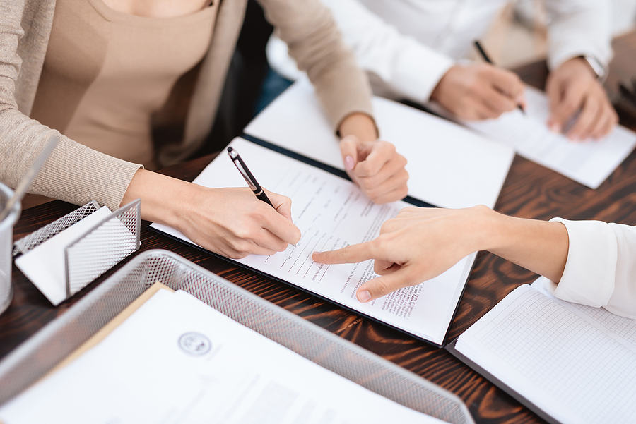 Couple sitting at an attorney's office receiving advice on how to fill out paperwork. 