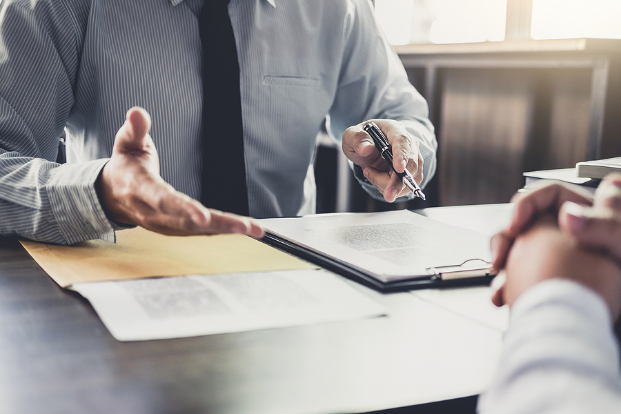 Closeup of an attorney meeting with a client in his office to discuss their case. 