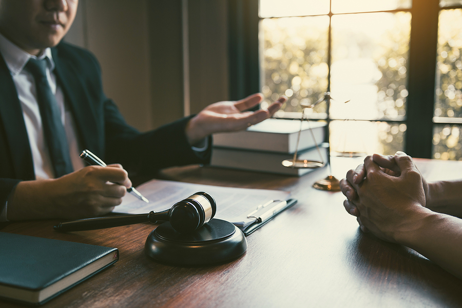 Male lawyer meeting with client in his office to discuss his case. 