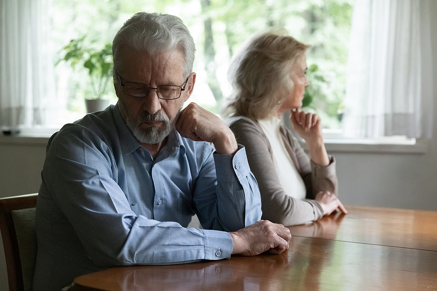 Frustrated mature couple sitting in an attorney's office going through a divorce. 