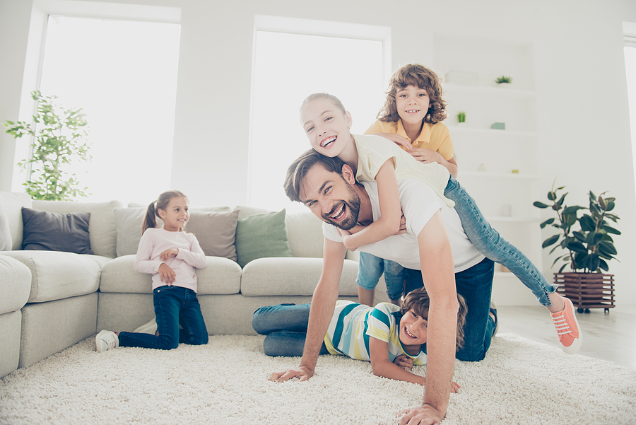Father playing on the floor with his kids.